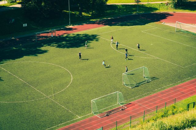 Sportplatz mit Fußball spielenden Kindern